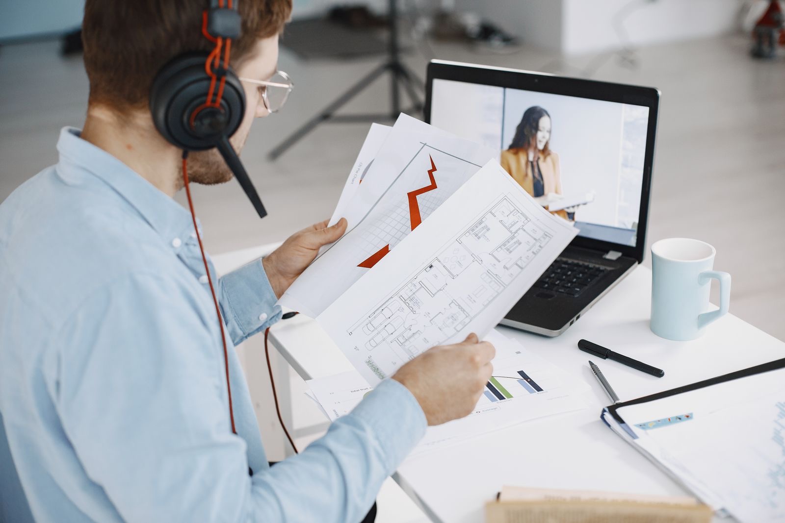 Company director abroad on a video call with a laptop and identity documents on the desk