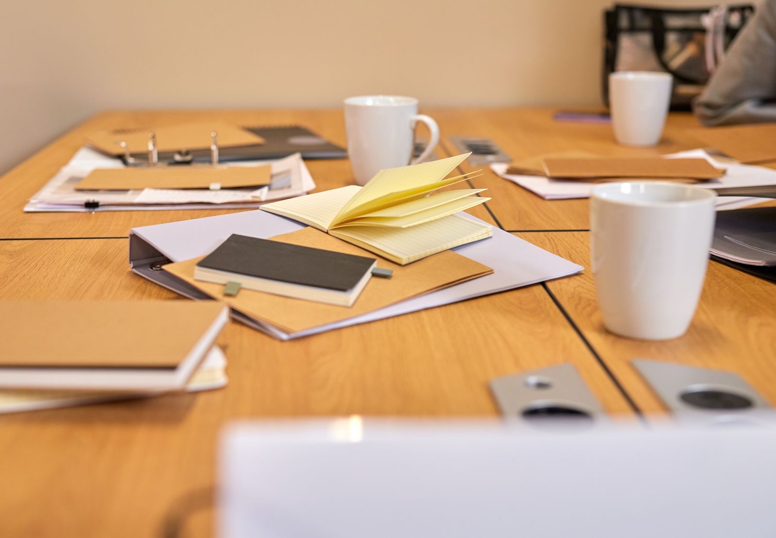 Document folders open on an office desk during a meeting