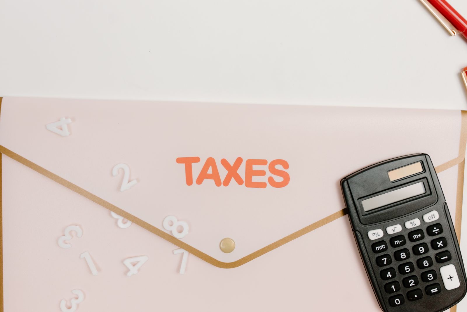 An invoice on a desk beside a calculator