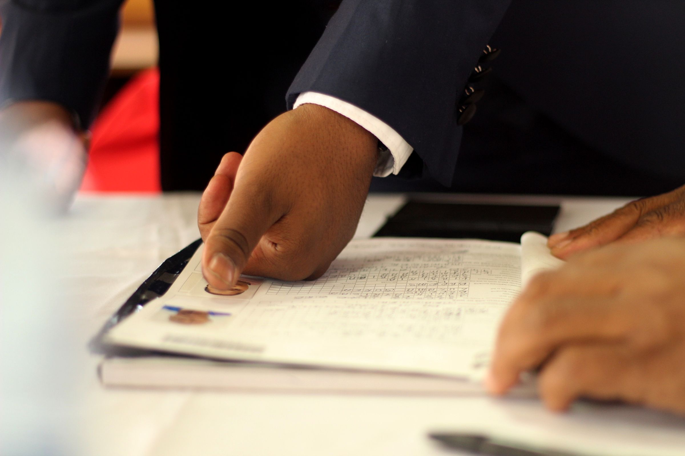 A notary's desk with a pen resting on a stack of signed pages