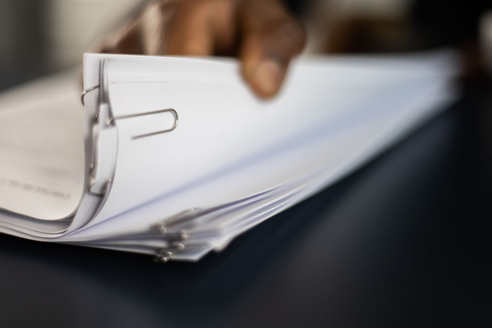 A stack of stamped documents in a folder on a desk