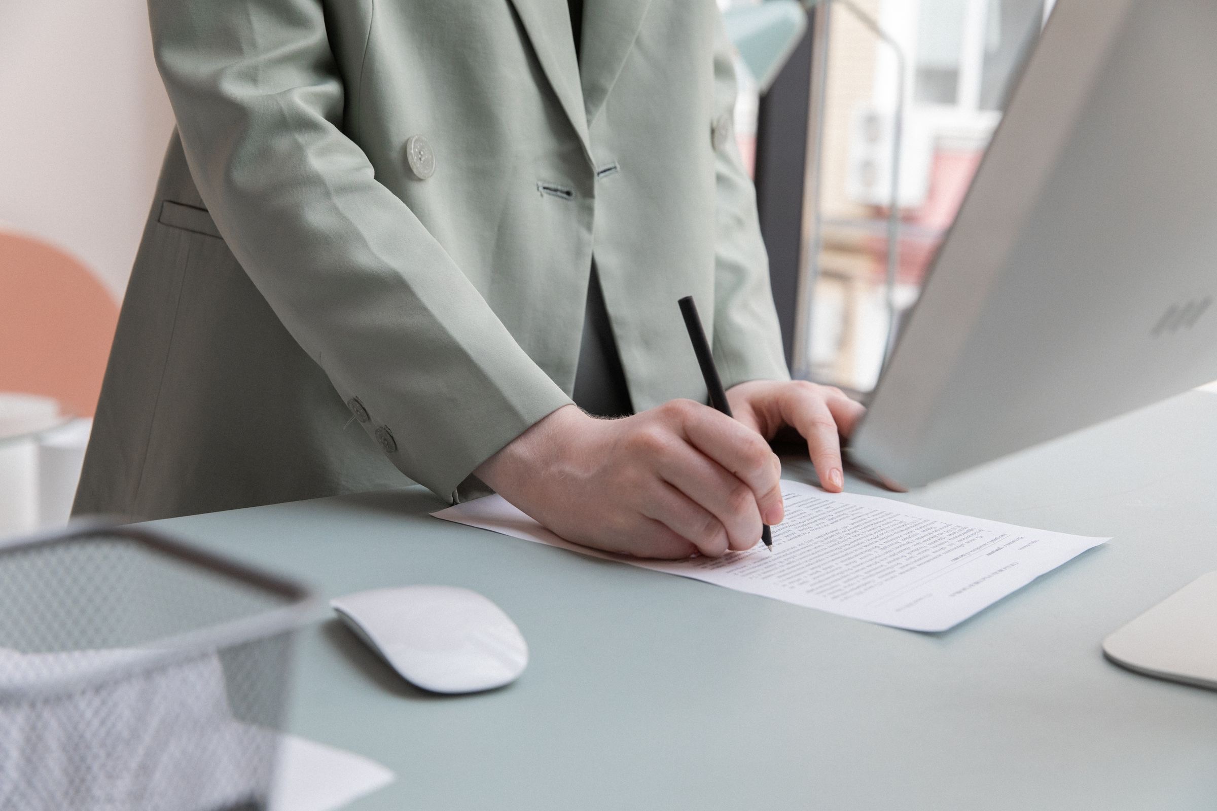 A person signing a document at a desk